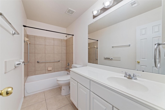 full bathroom with tile patterned flooring, vanity, tiled shower / bath, and toilet