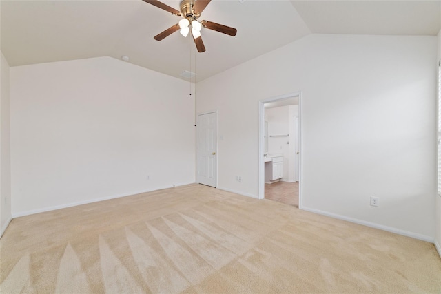 unfurnished bedroom with ceiling fan, light colored carpet, vaulted ceiling, and ensuite bath