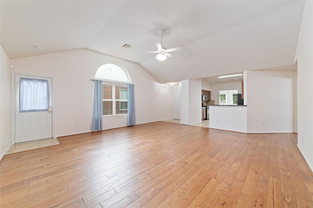 unfurnished living room with ceiling fan, vaulted ceiling, and light wood-type flooring