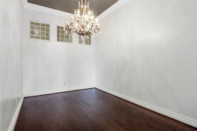 spare room featuring crown molding, dark hardwood / wood-style floors, and a chandelier