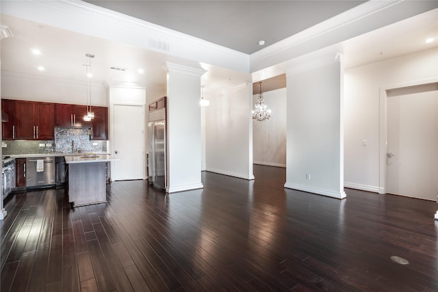 living room with a notable chandelier, dark wood-type flooring, ornamental molding, and sink