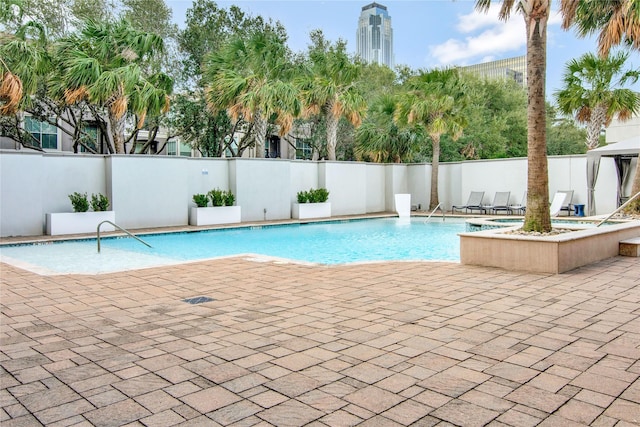 view of swimming pool featuring a fenced in pool, fence, and a patio