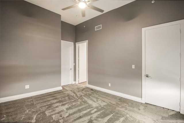 empty room with a ceiling fan, baseboards, visible vents, and carpet