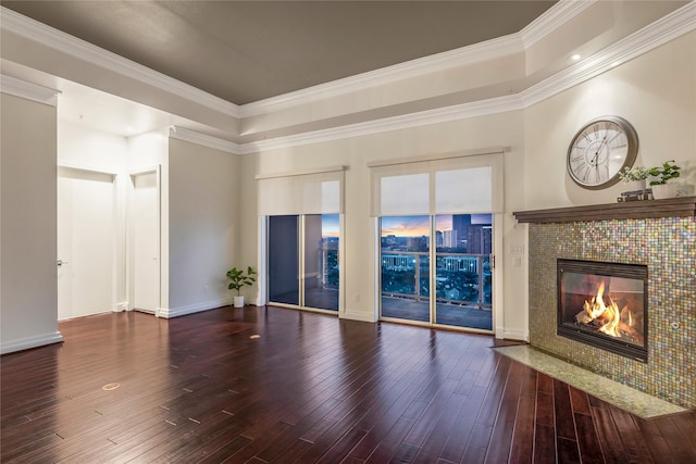 unfurnished living room with a raised ceiling, baseboards, a tile fireplace, ornamental molding, and hardwood / wood-style flooring