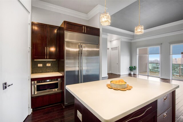 kitchen with stainless steel appliances, dark hardwood / wood-style floors, a center island, ornamental molding, and decorative backsplash