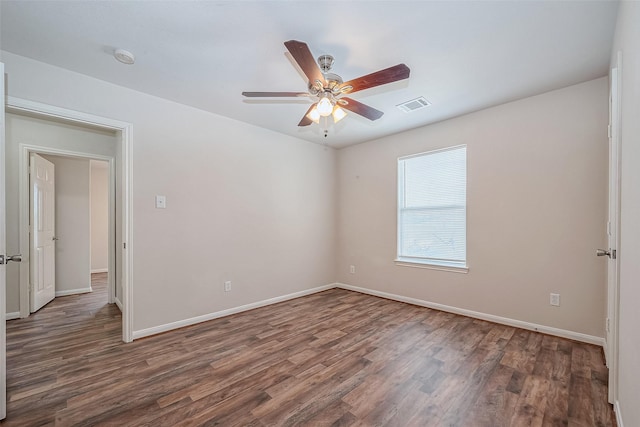 spare room with dark wood-type flooring and ceiling fan