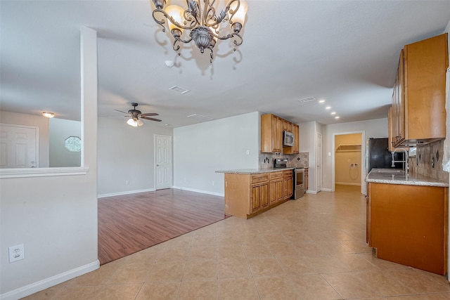 kitchen with backsplash, appliances with stainless steel finishes, and light tile patterned floors