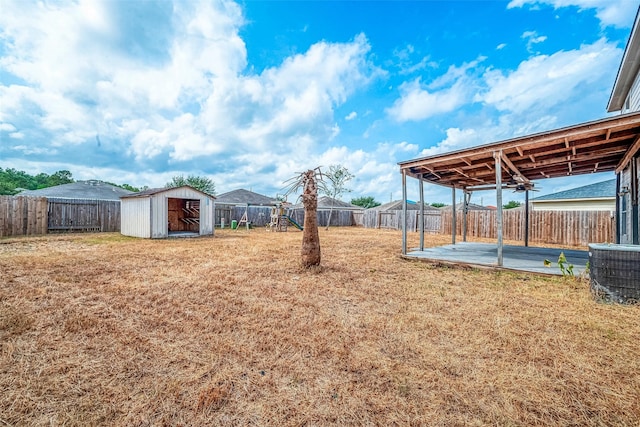 view of yard featuring central AC, a patio area, and a storage unit