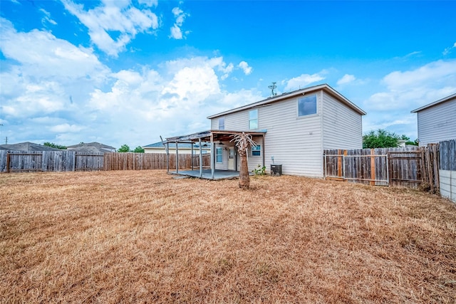 back of house featuring a lawn and a patio