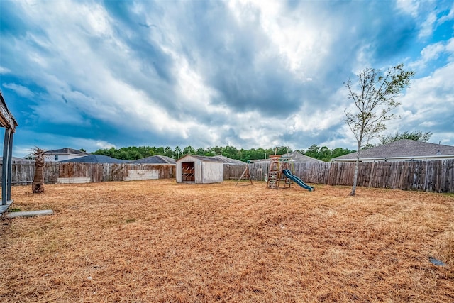 view of yard with a playground and a storage unit