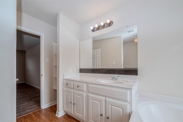 bathroom featuring a bath, vanity, and hardwood / wood-style floors