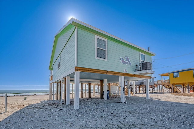 back of house featuring a view of the beach and a water view