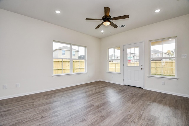 spare room with dark hardwood / wood-style floors and ceiling fan