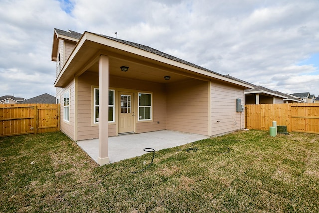 rear view of house with a patio and a lawn