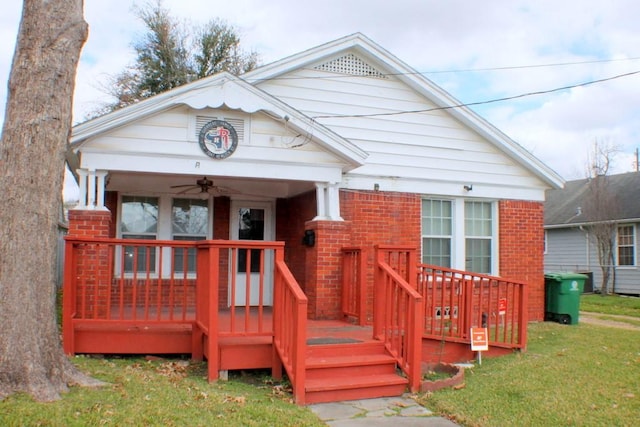 view of front of property with ceiling fan and a front yard