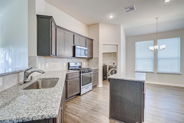 kitchen featuring appliances with stainless steel finishes, a center island, and light stone counters