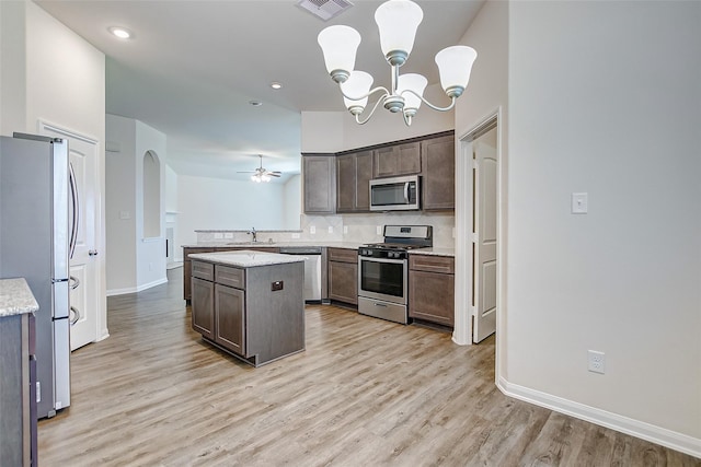 kitchen featuring stainless steel appliances, a kitchen island, sink, and dark brown cabinets