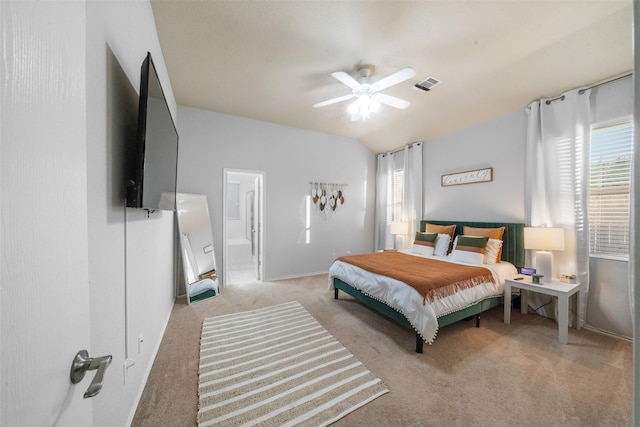 carpeted bedroom with ceiling fan, lofted ceiling, and ensuite bath