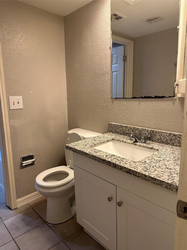 bathroom featuring vanity, toilet, and tile patterned flooring