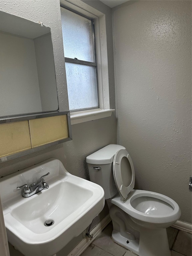 bathroom with tile patterned flooring, sink, and toilet