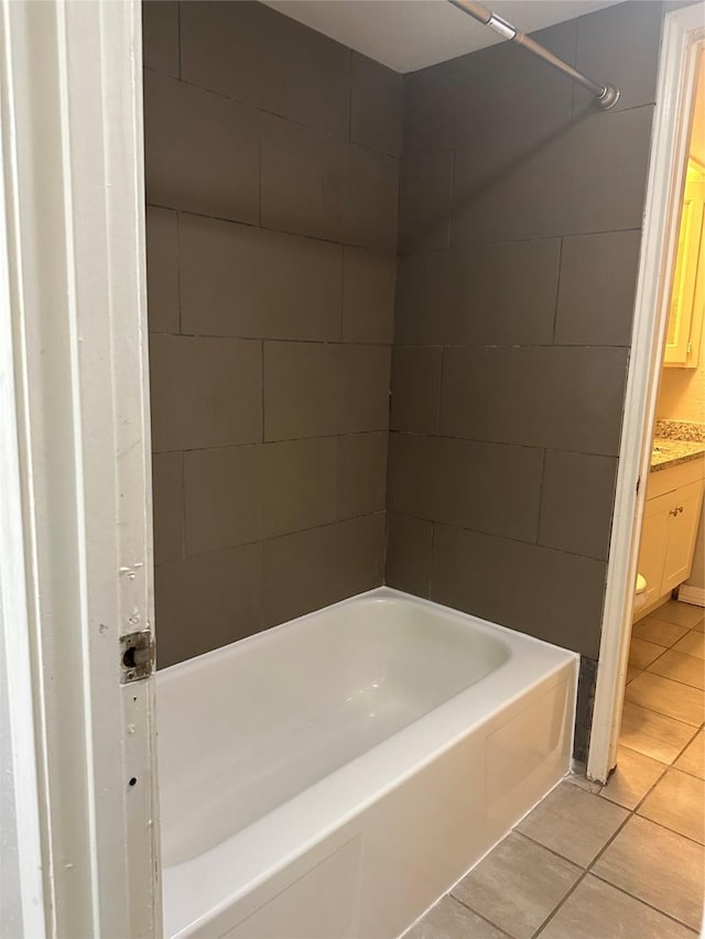 bathroom with tile patterned flooring, bathing tub / shower combination, and vanity