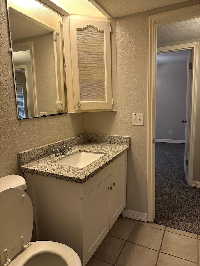 bathroom featuring vanity, tile patterned floors, and toilet