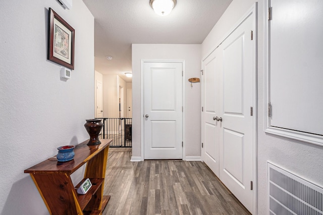 hall featuring hardwood / wood-style flooring and a textured ceiling