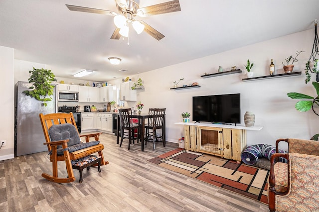 living room with ceiling fan and light hardwood / wood-style floors