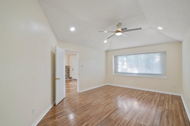 empty room featuring ceiling fan, vaulted ceiling, and wood-type flooring