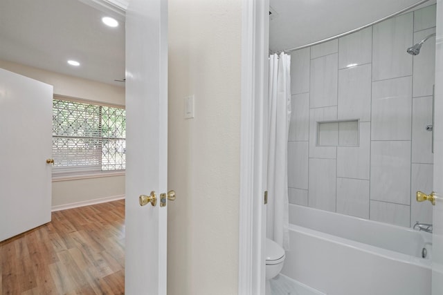 bathroom with shower / bathtub combination with curtain, wood-type flooring, and toilet