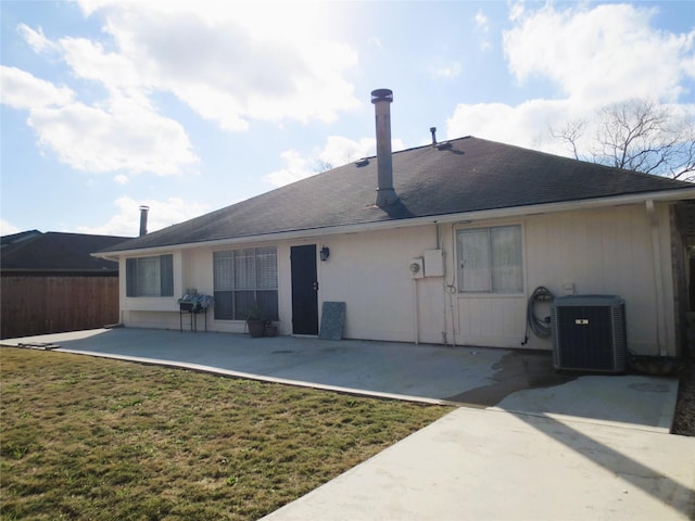 rear view of property with a yard, a patio, and central air condition unit