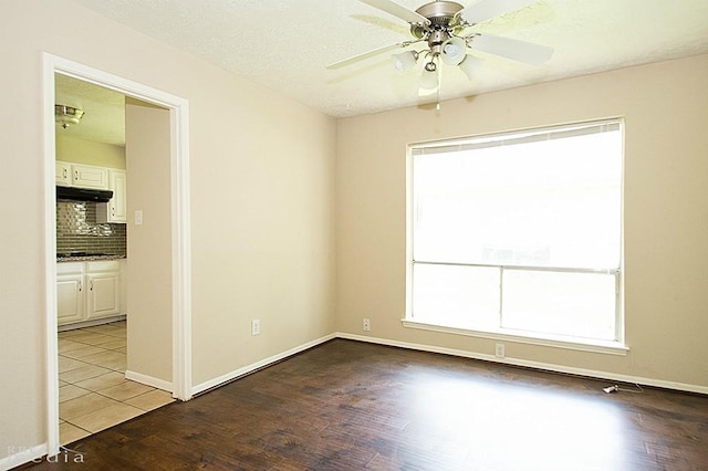 unfurnished room featuring hardwood / wood-style flooring, ceiling fan, and a textured ceiling