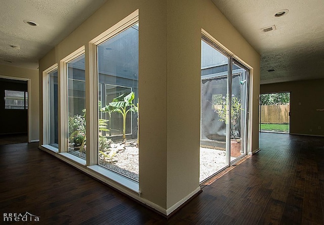 entryway with a textured ceiling and dark hardwood / wood-style flooring