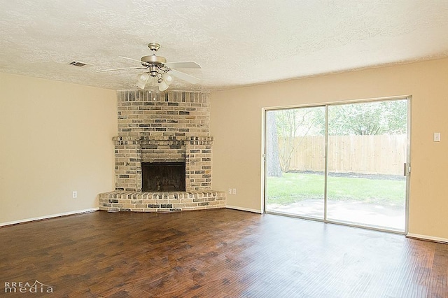 unfurnished living room featuring ceiling fan, a textured ceiling, a fireplace, and wood-type flooring