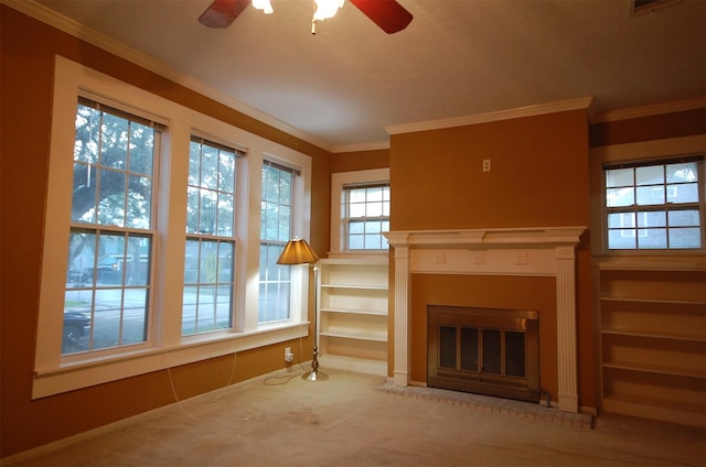 unfurnished living room with crown molding, ceiling fan, carpet flooring, and a brick fireplace