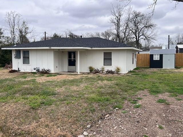 ranch-style home with a storage shed and a front yard