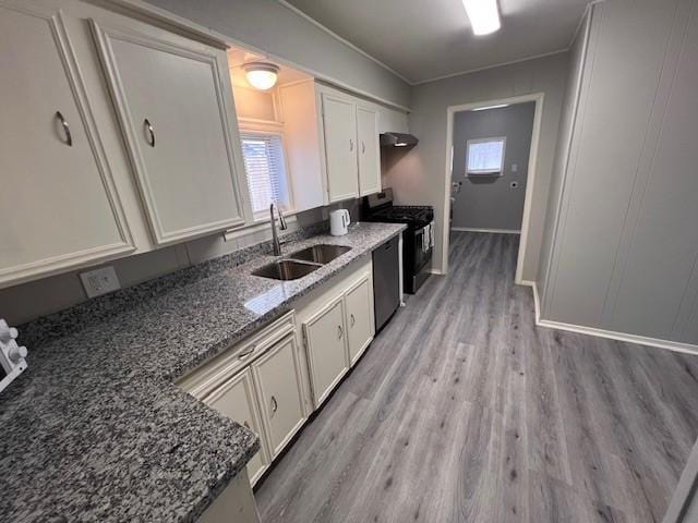 kitchen featuring sink, white cabinets, dark stone counters, black appliances, and light wood-type flooring