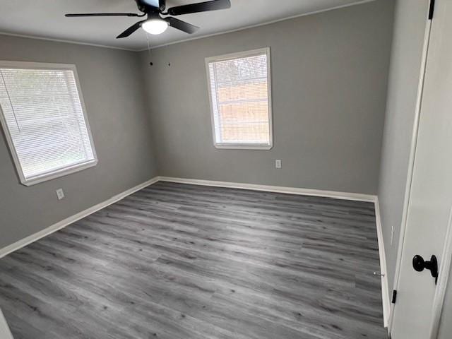 empty room with ceiling fan, ornamental molding, and dark hardwood / wood-style flooring