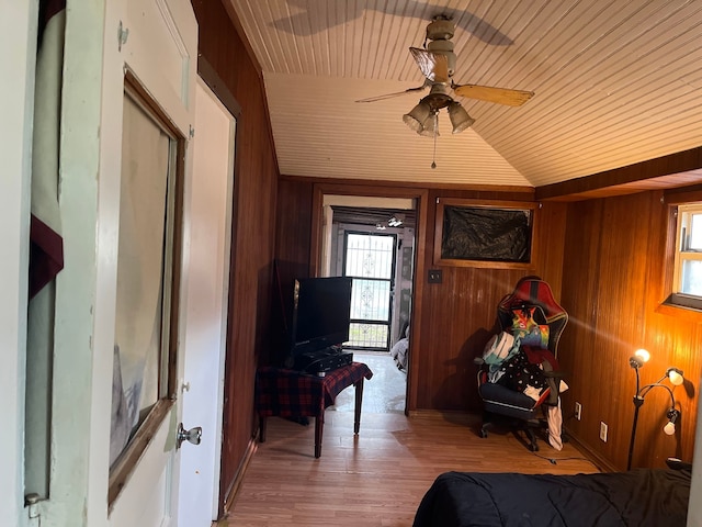 bedroom with wooden ceiling, vaulted ceiling, wood-type flooring, and wood walls