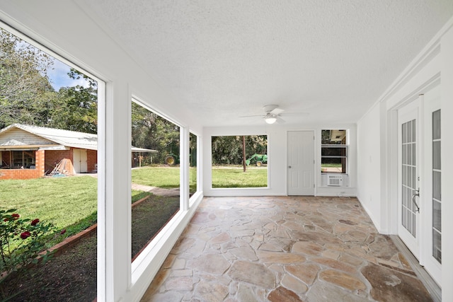 unfurnished sunroom featuring ceiling fan