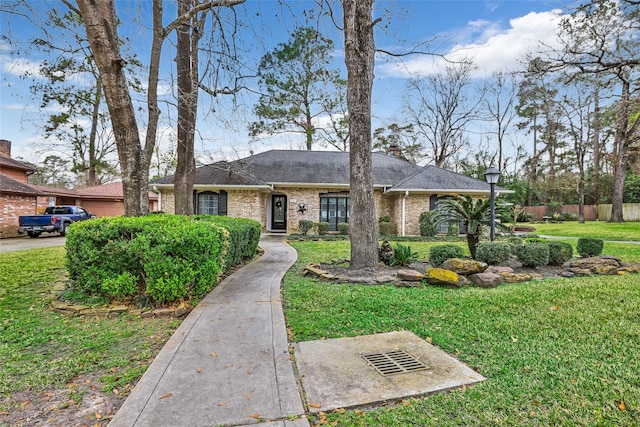 735 Angelina Dr, Conroe, TX 77302 - ranch-style home featuring fence, a front yard, a shingled roof, and brick siding