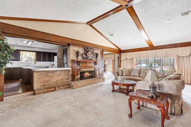 living room featuring lofted ceiling with beams, light colored carpet, a textured ceiling, and a fireplace