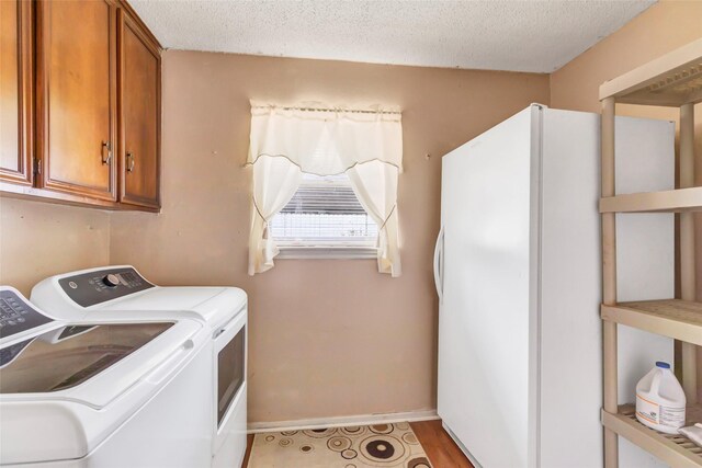 735 Angelina Dr, Conroe, TX 77302 - laundry area with a textured ceiling, separate washer and dryer, cabinet space, and baseboards