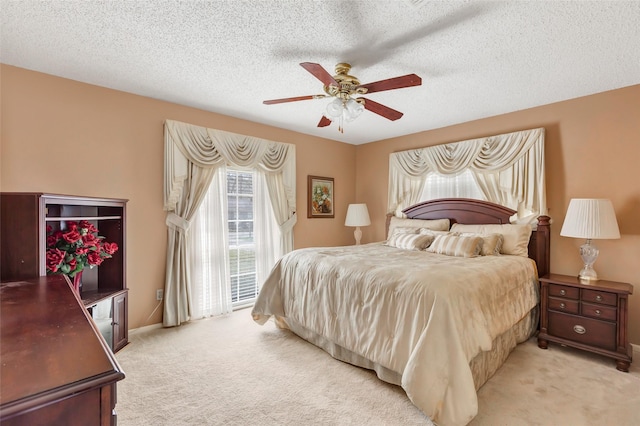 bedroom featuring ceiling fan, access to outside, light colored carpet, and a textured ceiling