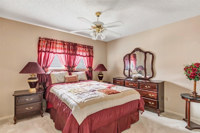 carpeted bedroom with ceiling fan and a textured ceiling