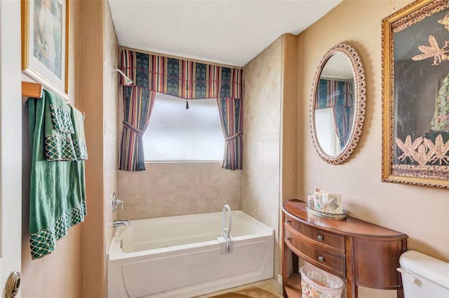 bathroom with toilet, a bathing tub, and a textured ceiling