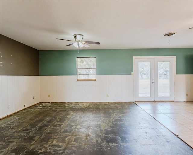 empty room featuring a healthy amount of sunlight, ceiling fan, and french doors