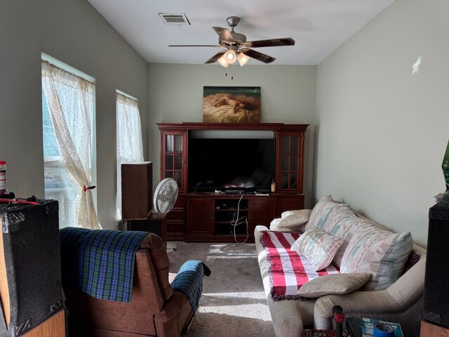 carpeted living room with ceiling fan