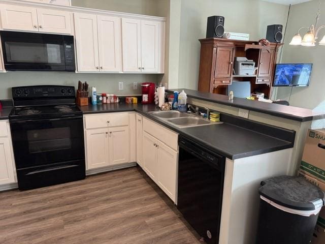 kitchen featuring white cabinetry, kitchen peninsula, sink, and black appliances