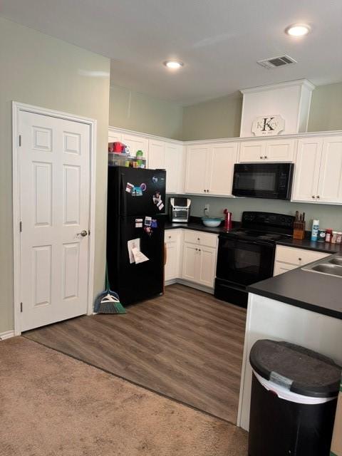 kitchen featuring sink, black appliances, dark hardwood / wood-style floors, and white cabinets